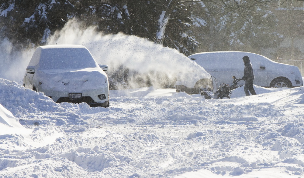 12月25日，在加拿大多倫多，一名男子幫助一輛在雪地中打滑的汽車脫困。