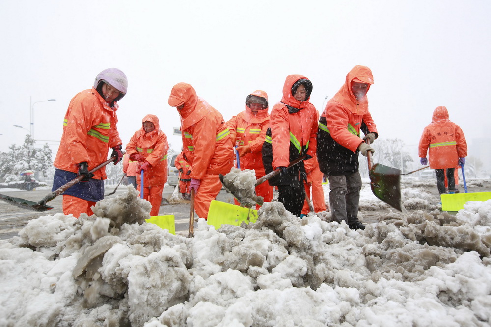 1月4日，環衛工人在江蘇省盱眙縣街頭清理路面積雪。  新華社發（顏懷峰 攝）
