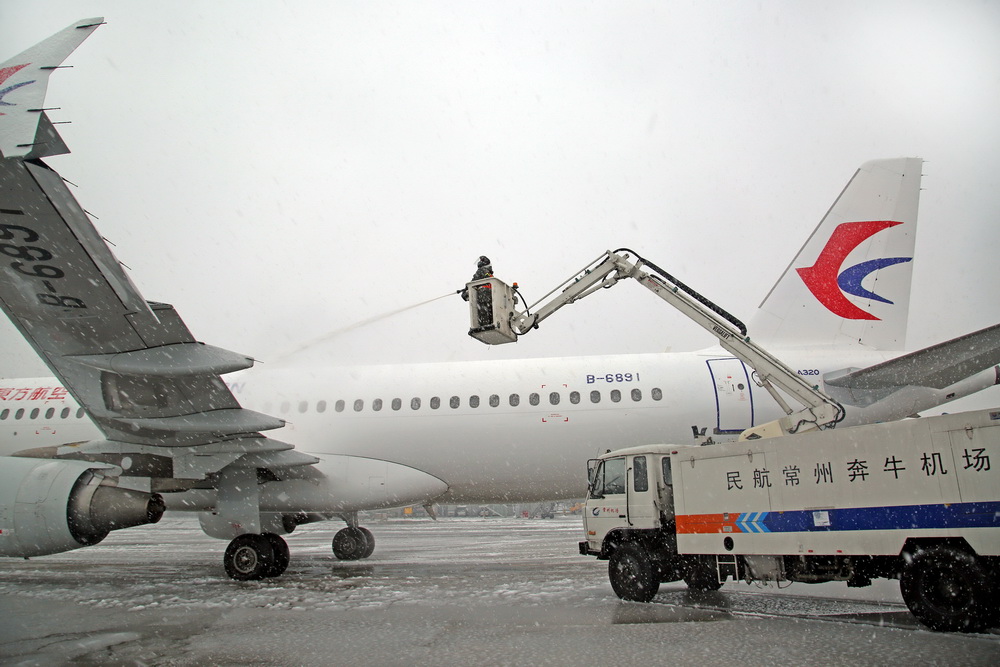 1月4日，江蘇常州機場的工作人員在給飛機除冰。  新華社發（陳暐 攝）