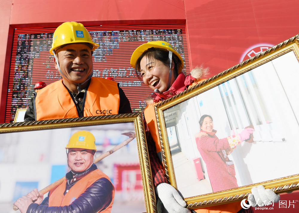 1月9日，北京城市副中心一处安置房工地，农民工夫妇黄春平（左）和曾风在比拼谁的照片更美。（徐烨/摄）