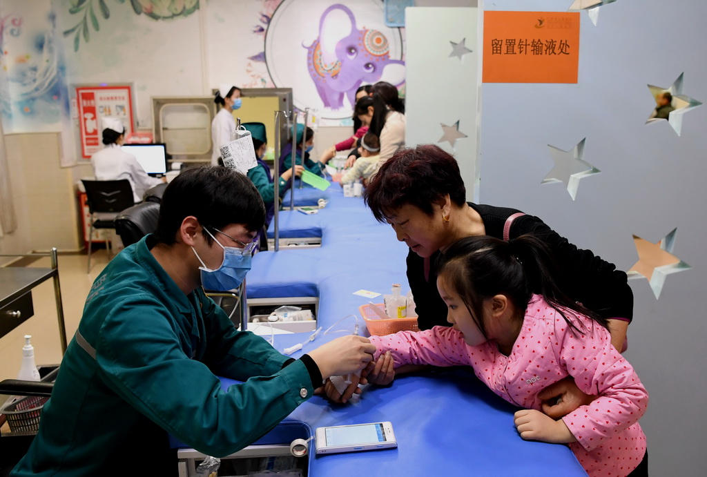 在郑州市儿童医院输液大厅，医务人员在为患儿输液（1月3日摄）。 新华社记者李安摄