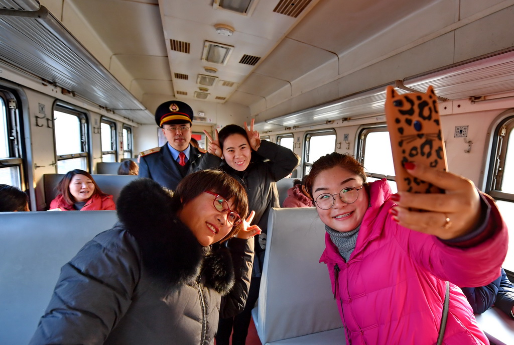 1月18日，旅客在唐山市古冶車站與唐山南站區間運行的火車上拍照留念。 新華社記者楊世堯攝