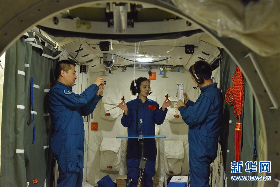 2013年5月22日，航天員王亞平（中）、聶海勝（右）、張曉光在模擬天宮一號組合體內進行太空授課訓練。