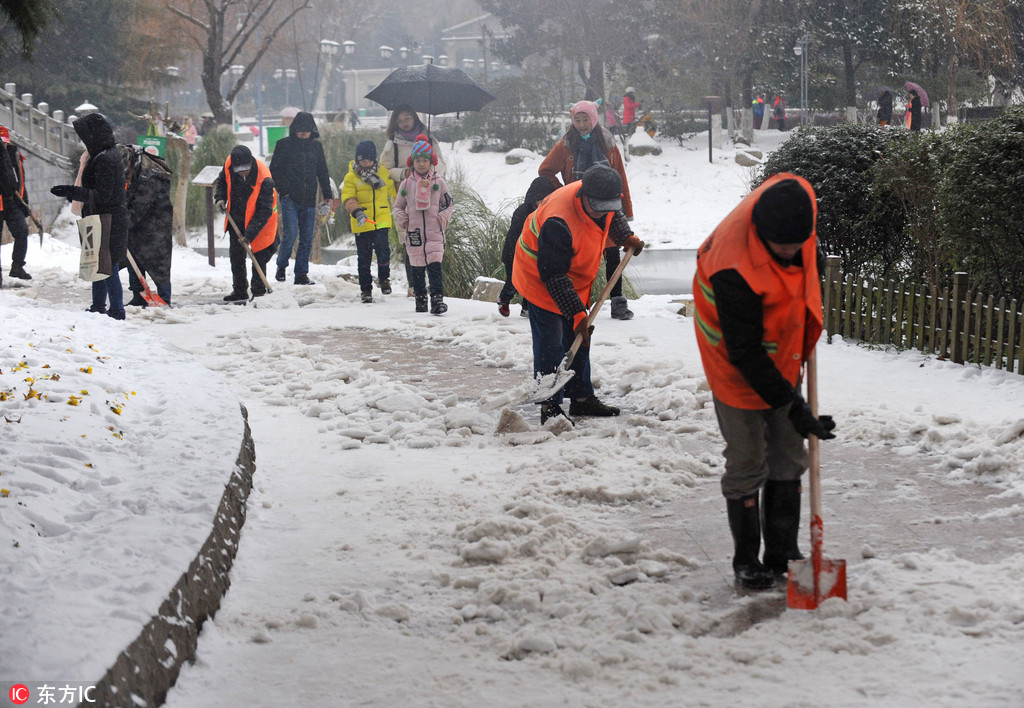 1月27日，武漢街頭，市民在冰天雪地裡前行。