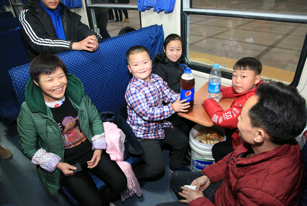 北京至重慶的春運首發車上，幾名小朋友要回家過年了，滿臉開心。