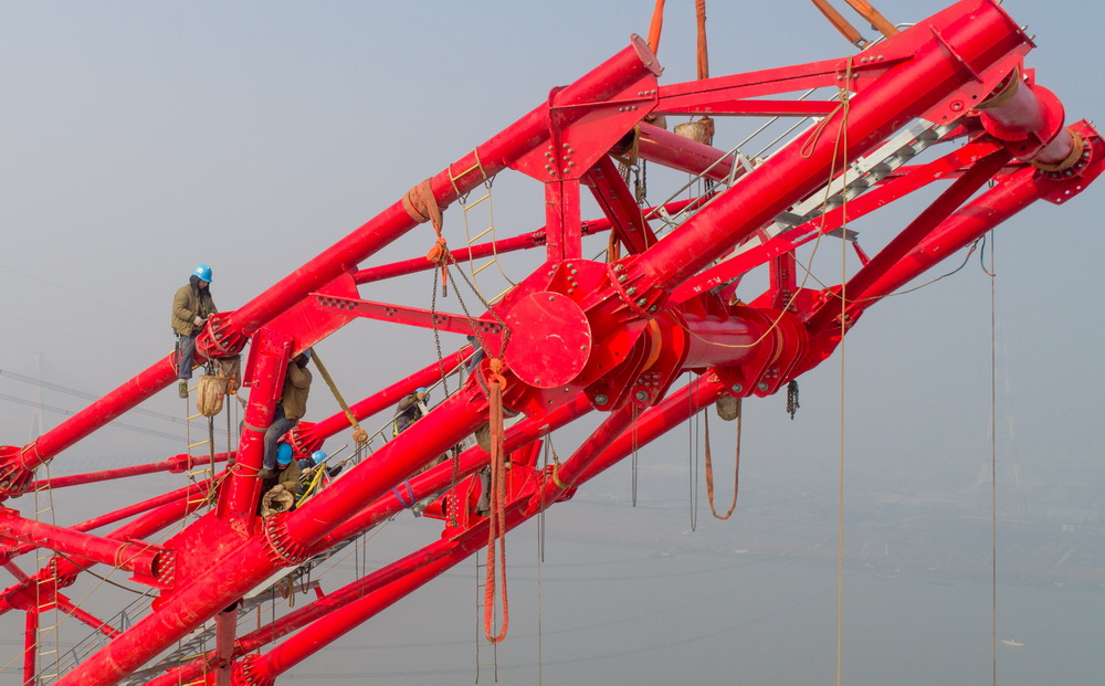 2月6日，在安徽省繁昌县荻港镇，跨越塔在进行横担就位施工（无人机航拍）。