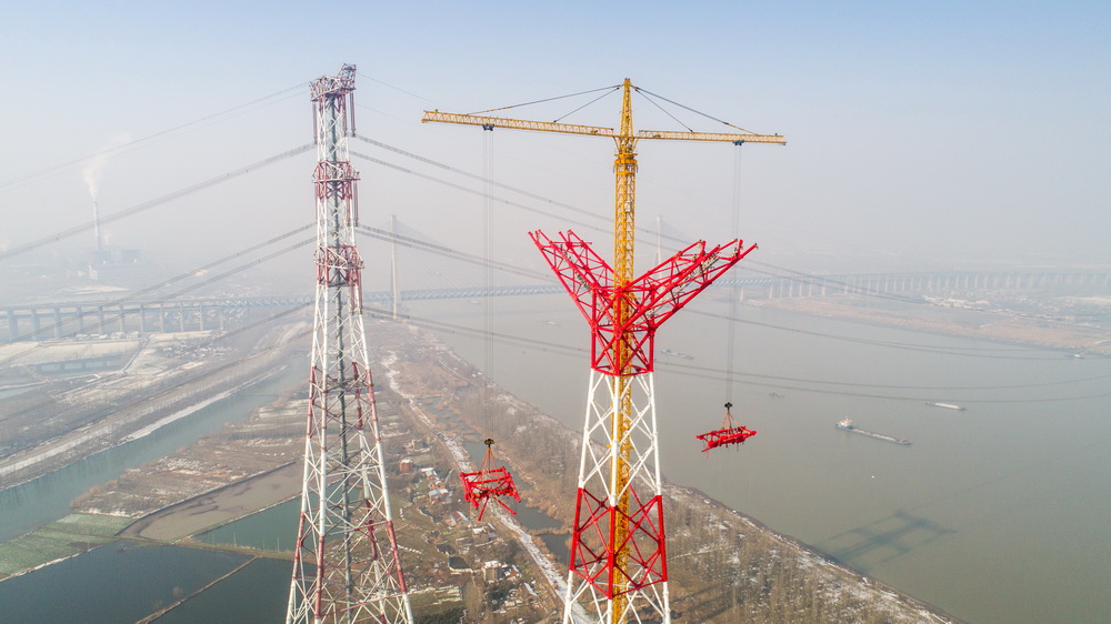 2月6日，在安徽省繁昌县荻港镇，跨越塔在进行横担吊装施工（无人机航拍）。