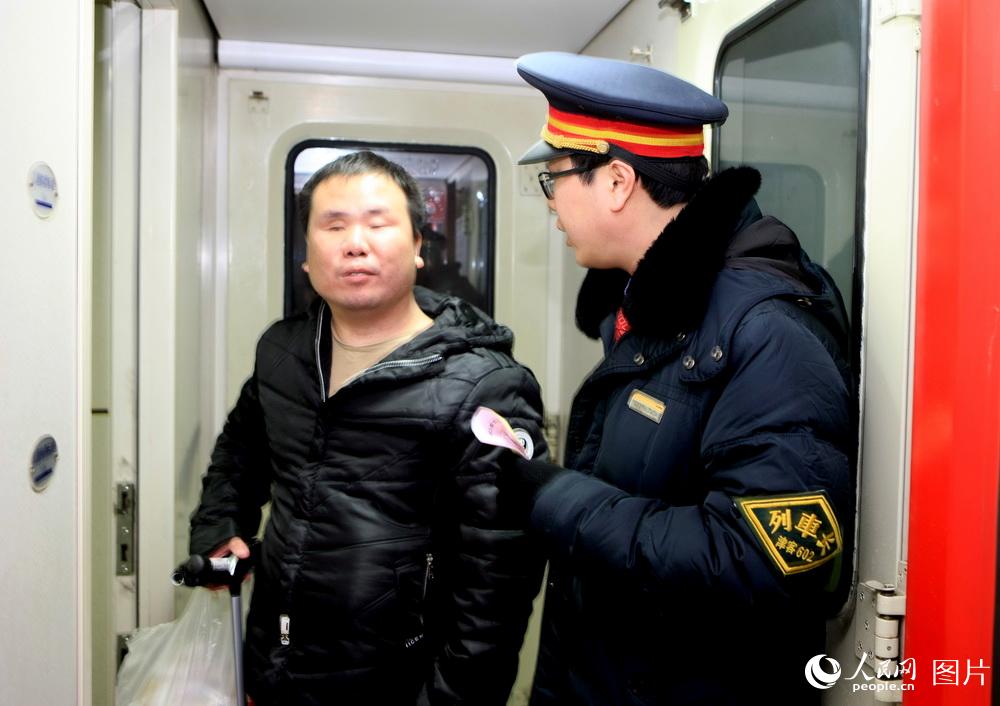 2月7日，K213次列車長張鵬將天津站送來前往西安的盲人李建紅接上車並安排臥鋪。     高錦旭 攝