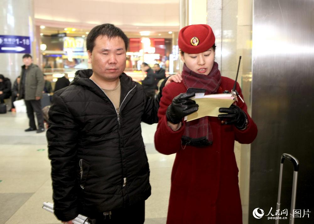 2月7日，天津站365高鐵玫瑰客運員閆雲婷為盲人旅客聯系所乘列車。高錦旭 攝