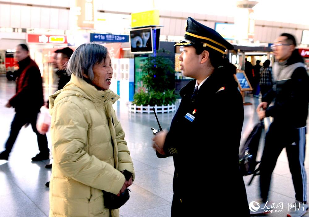 2月7日，天津站客運值班員告訴前往北京的大娘，您別著急，放心車到時，我會送您上車。讓大娘感到溫馨。高錦旭　攝
