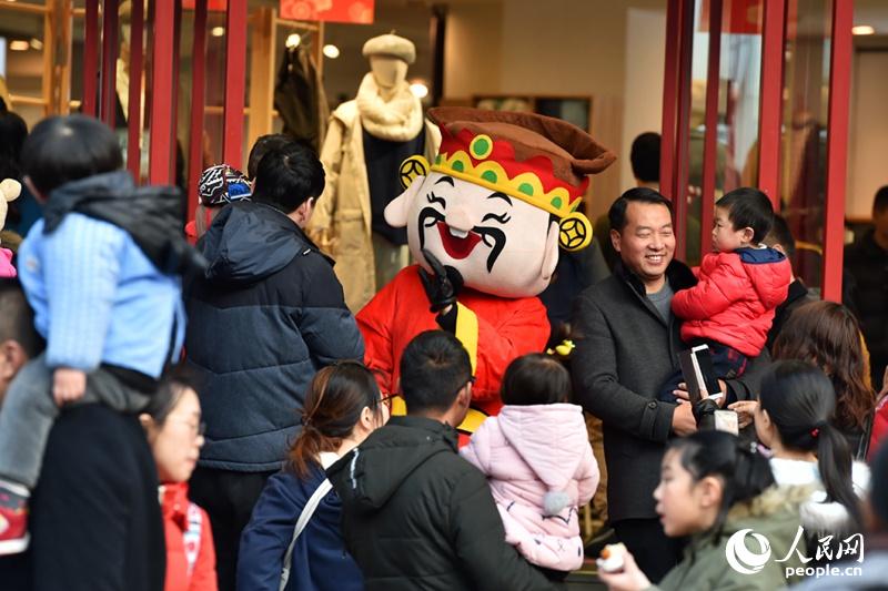 2月17日，南京東路步行街，游客與財神玩偶合影留念。（人民網記者 翁奇羽 攝）