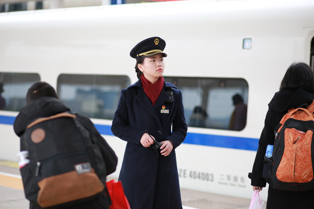 2018年2月23日，廣安南站，在人群中工作的譚佳運。
