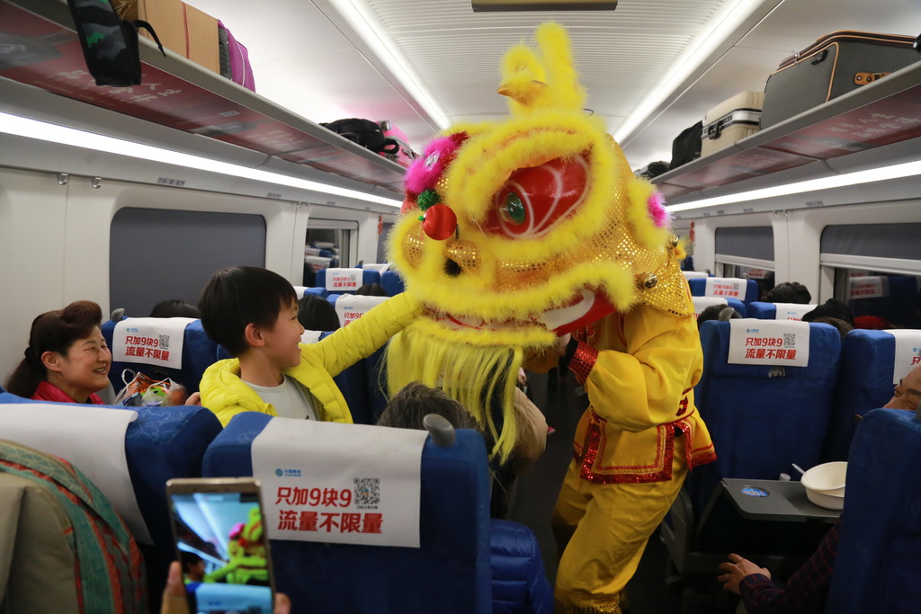 2018年3月1日，在重慶北開往成都東的G8526次列車上，工作人員正在給旅客表演舞龍獅。