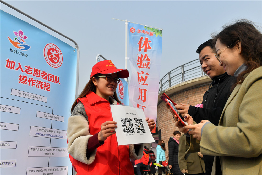 3月3日，在河北省石家庄市橋西區，市民通過掃描二維碼了解加入志願者團隊相關流程。新華社發（張震 攝）
