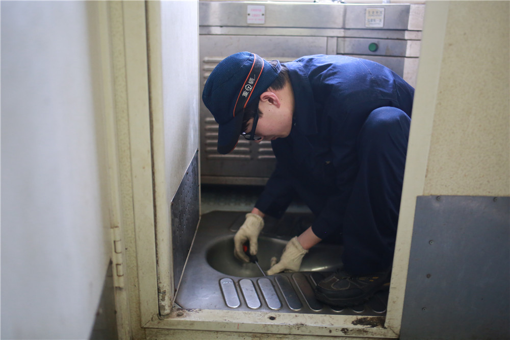 2018年3月5日，重慶車輛段重慶北運用車間廁所革命整治小組成員孫涌修理K1078次集便器的噴嘴。