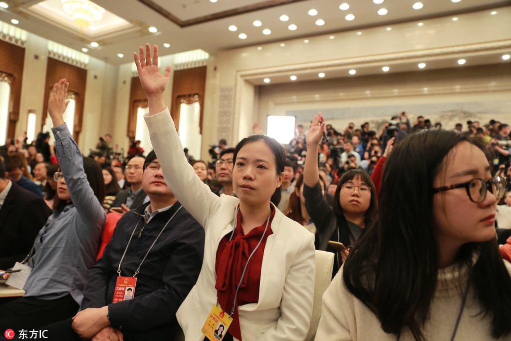 女記者舉手爭取提問機會。