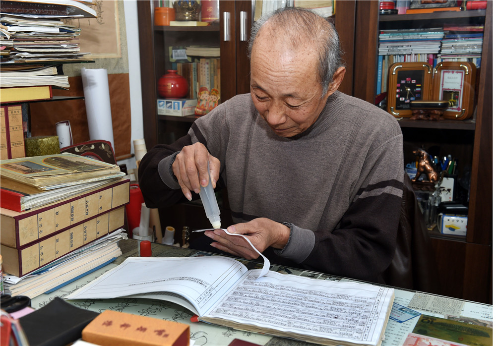 青島退休教師張偉源在整理工資條（3月8日攝）。