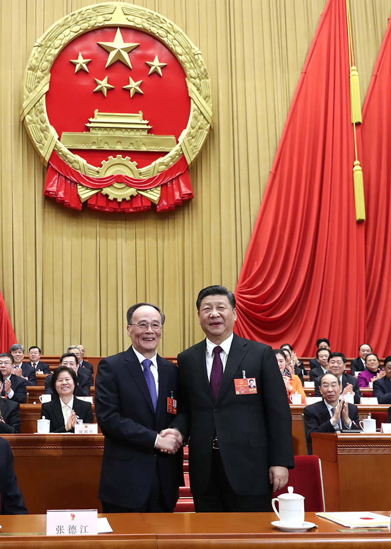 習近平在主席台上同新當選的國家副主席王岐山握手。新華社記者 鞠鵬 攝