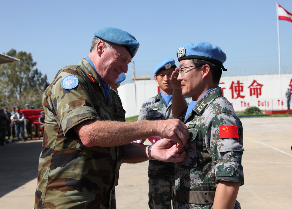 4月6日，在黎巴嫩南部辛尼亞村的中國赴黎維和部隊多功能工兵分隊營區，聯合國駐黎臨時部隊（聯黎部隊）司令比爾裡（前左）為中國第16批赴黎維和部隊指揮長黃雲佩戴聯合國“和平榮譽勛章”。 