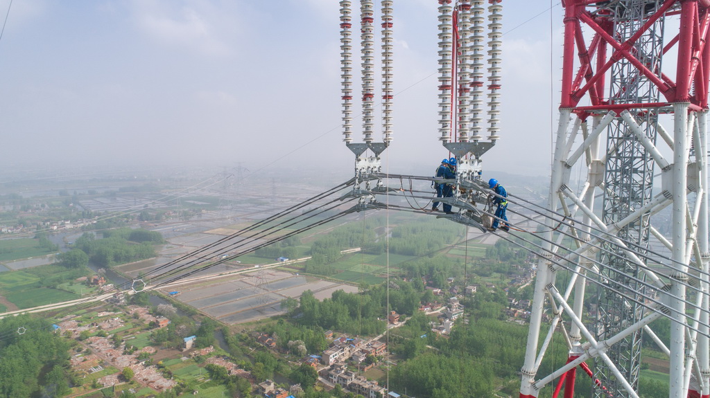 4月15日，在安徽省無為縣高溝鎮，工人們在昌古特高壓長江大跨越工程跨越塔導線上進行高空作業（無人機拍攝）。 新華社記者 郭晨 攝
