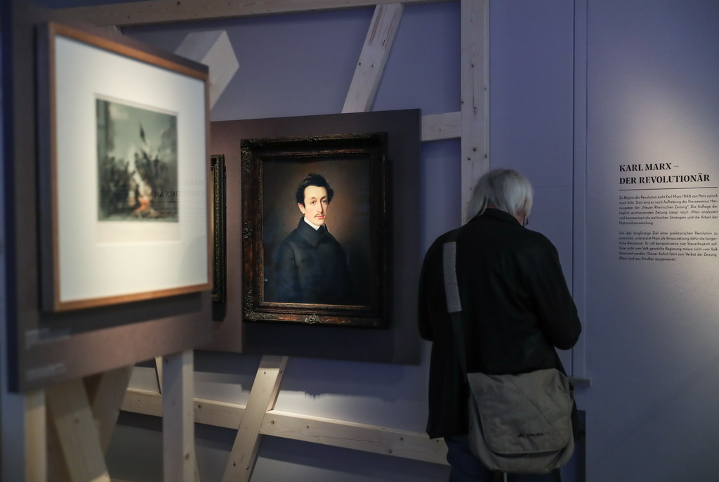 5月3日，在德國特裡爾的萊茵流域州立博物館，一名參觀者觀看馬克思主題展。新華社記者單宇琦攝