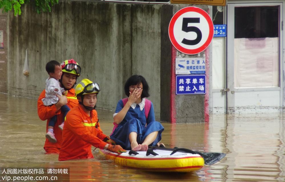 5月7日，在積水嚴重的廈門市思明區東坪山路，消防官兵轉移被困人員。