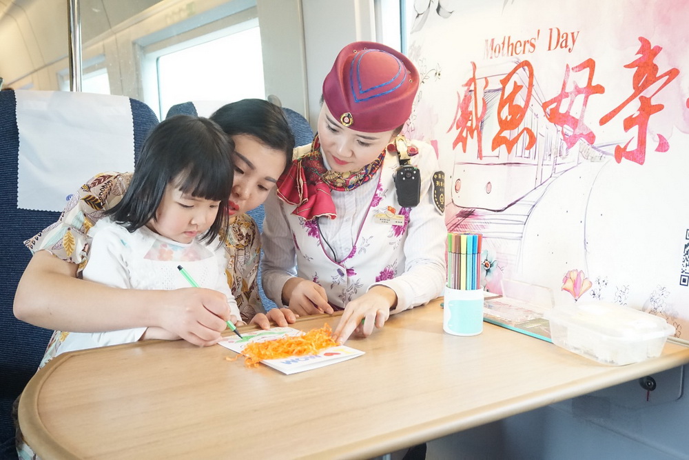 乘务员邀请旅客参与母子游戏，一同制作精美的手工贺卡。