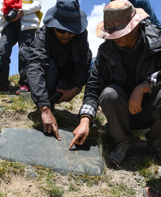 考察人員在查看稱多縣稱文鎮白龍村科哇岩畫點的遺跡（5月14日攝）。新華社記者 李賀 攝
