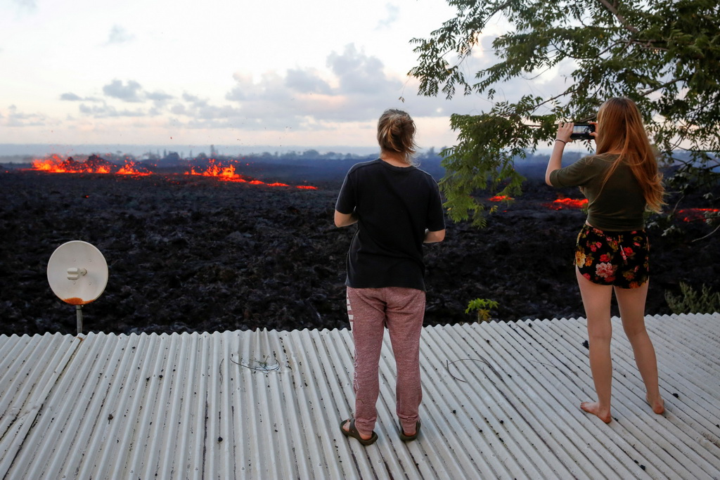 5月14日，在美國夏威夷帕霍阿，當地居民拍攝地面裂縫中冒出的熔岩。