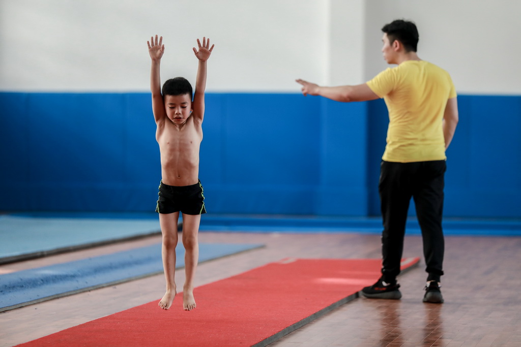 教练员刘亚（右）在榕江县少年儿童业余体操运动学校内对小学员叶占嵩进行指导（5月15日摄）。 新华社记者刘续摄 