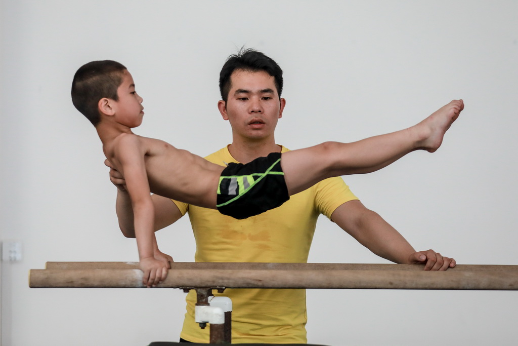 教练刘亚（后）在榕江县少年儿童业余体操运动学校内对小学员龙水华进行指导（5月15日摄）。新华社记者刘续摄 