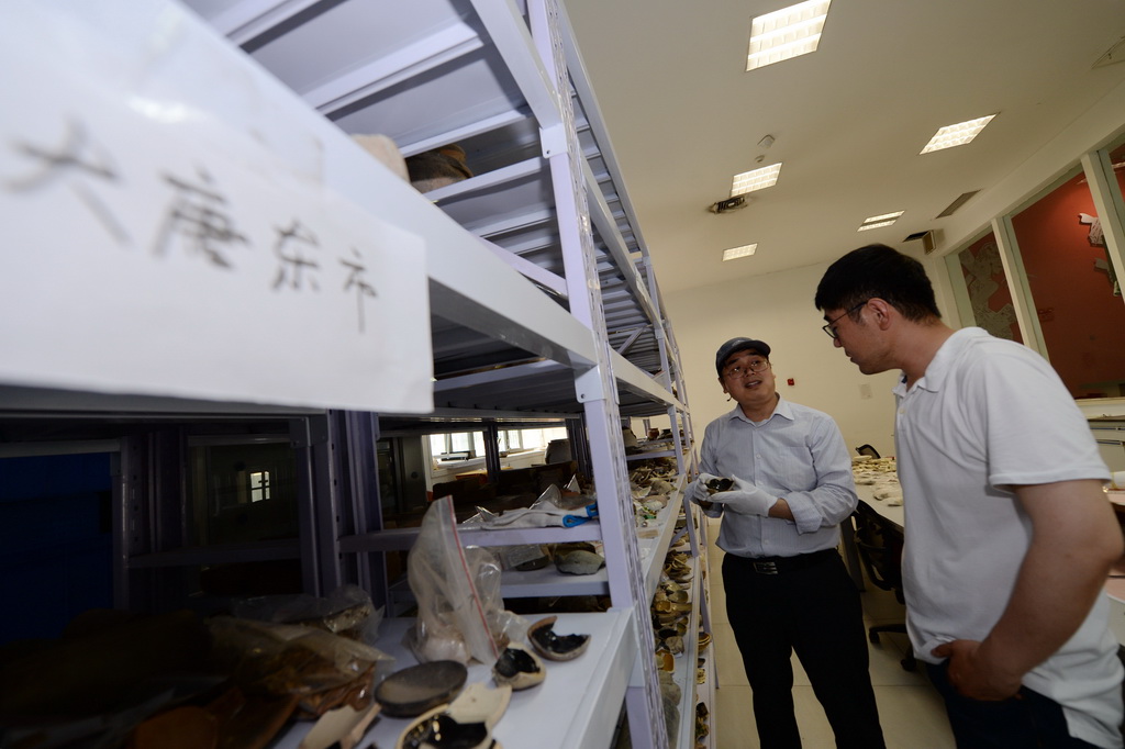 5月15日，中國社會科學院考古研究所西安唐城考古隊負責人李春林（左）和隊員王子奇查看西安隋唐長安城東市遺址出土的遺物。 新華社記者 李一博 攝