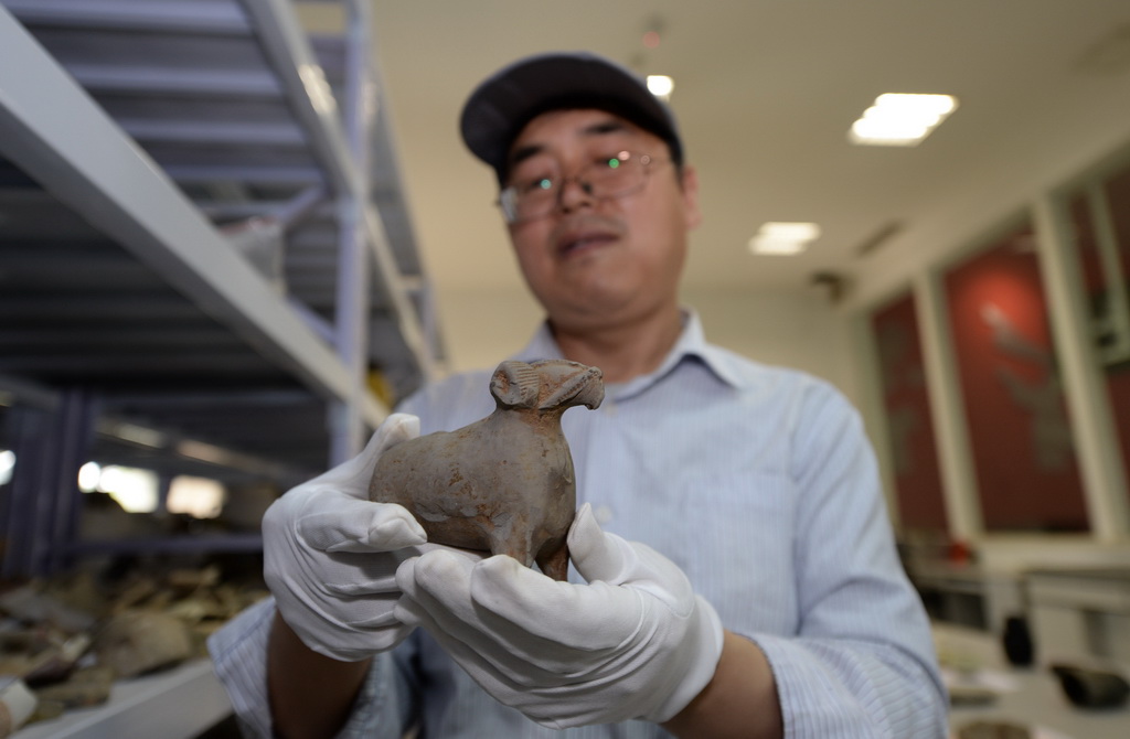 5月15日，考古工作者展示西安隋唐長安城東市遺址出土的陶羊。新華社記者 李一博 攝