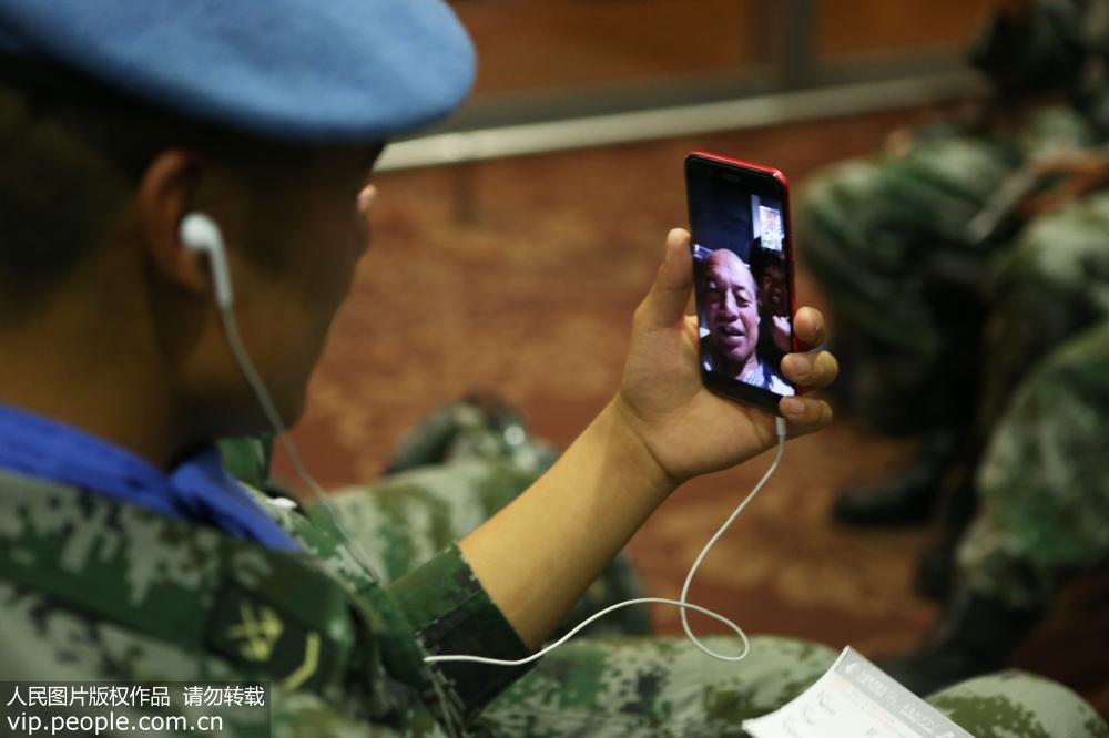 維和分隊官兵在機場候機大廳與家人視頻。