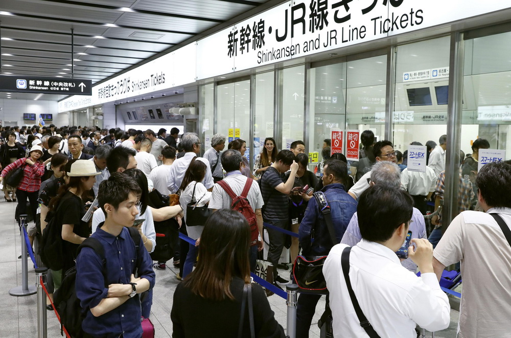 6月18日，在日本大阪，人們在新干線恢復運行后排隊買票。新華社/美聯