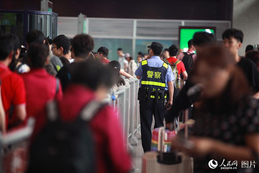 民警在成都東客站進站口維護旅客進展秩序。