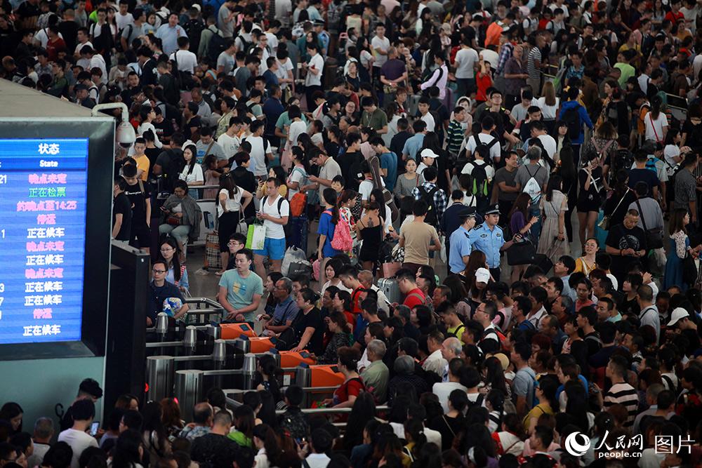 民警在成都東客站候車室人群中巡查守護，確保旅客平安。