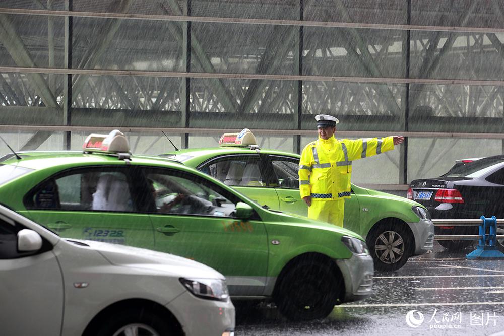 民警在成都東客站進站匝道冒雨指揮車輛快速通行。