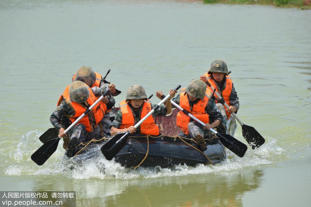 7月13日，女兵小组队员合力操纵橡皮艇，破浪前行。