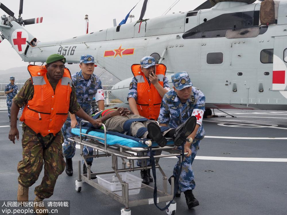 7月17日，在中国海军和平方舟医院船飞行甲板，中巴新医护人员一起转运伤员。