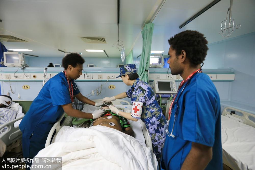 7月17日，在中国海军和平方舟医院船病房，中巴新医护人员对住院伤员进行护理。