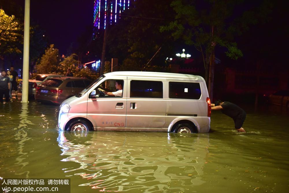 7月18日晚，在河北省石家庄新樂市新華路上，一汽車拋錨在大水中。