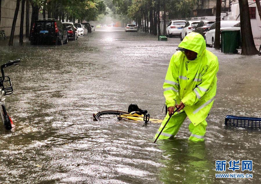 7月24日，排水工人在天津河西區積水路段進行排水作業（手機拍攝）。新華社發 王青岩 攝