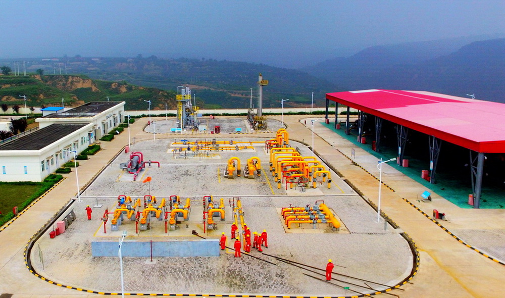 圖為：延川南煤層氣田職工在中心脫水處理站接排污管線。