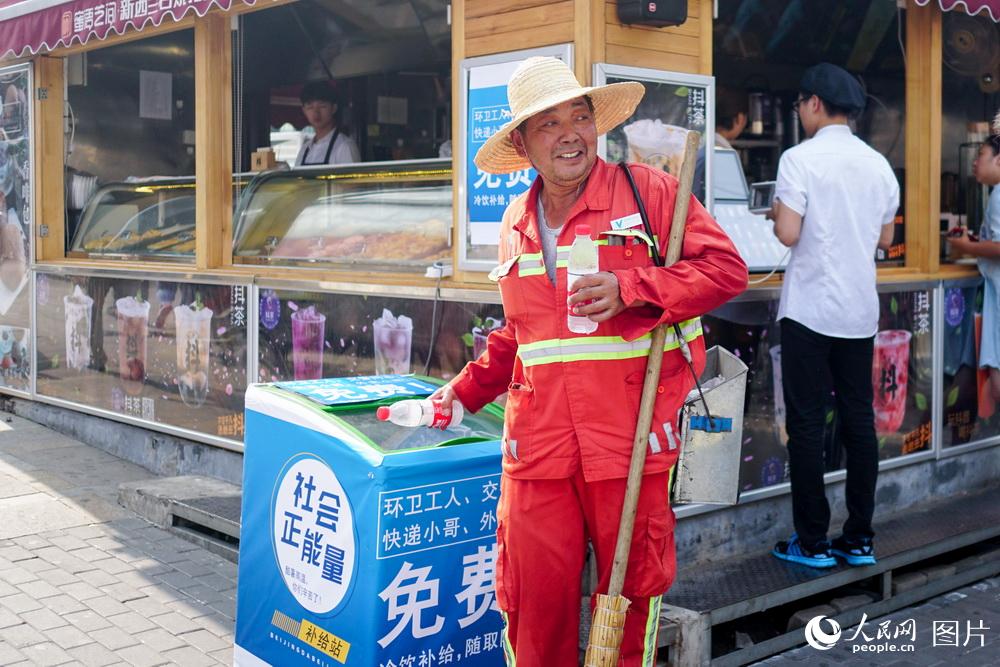 2018年7月31日，環衛工人路過“愛心冰箱”，取走冰水。（人民網記者 韓淑賢 攝）