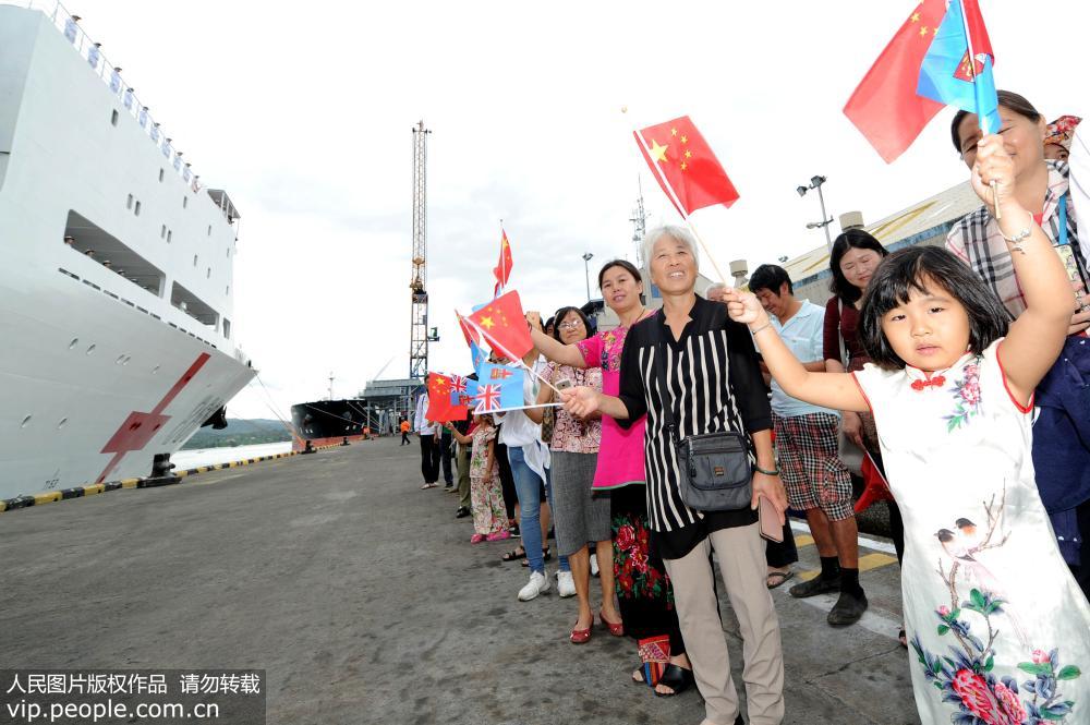 當地時間8月9日，在斐濟蘇瓦港碼頭，一名小朋友揮動中斐兩國國旗為中國海軍和平方舟醫院船送行。