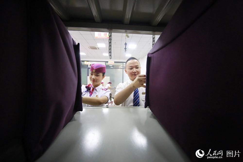 潘慶（右）和黃敏(左)在列車員工作區領取自己的工作行李箱。