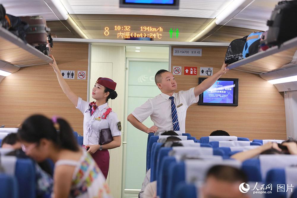 潘慶（右）和黃敏(左)一起整理行李架的行李,並檢查整理旅客們的行李是否放置得安全可靠。