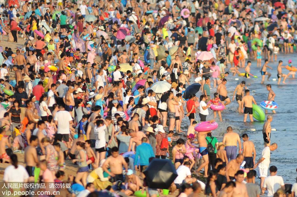 青島34℃高溫來襲 游客海灘密集扎堆避暑納涼