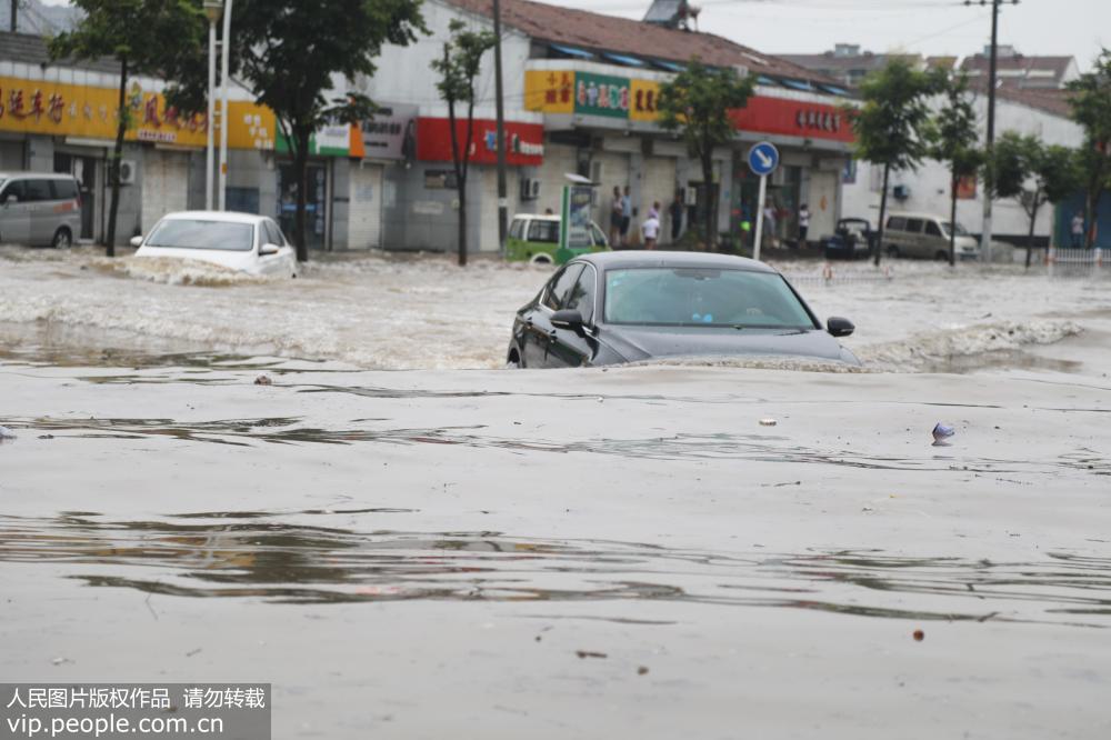 2018年8月19日，江蘇豐縣城區一片汪洋，行人車輛涉水而行。